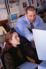 A teacher provides guidance and encouragement to a student in a computer assignment