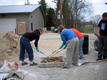 Eco-house students mixing plaster Carleton College
