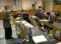 instructor leading interactive lecture demonstration on water quality using samples of drinkingn water