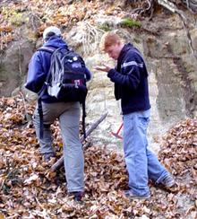 Decorative image showing students examining an outcrop.